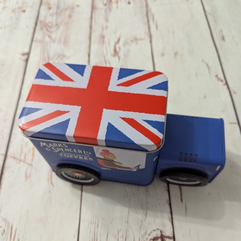 Puszka z flagą w kształcie samochodu retro z ruchomymi kołami