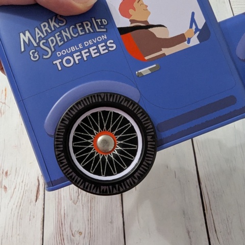 Puszka z flagą w kształcie samochodu retro z ruchomymi kołami