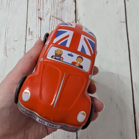 Puszka z flagą w kształcie samochodu z ruchomymi kołami