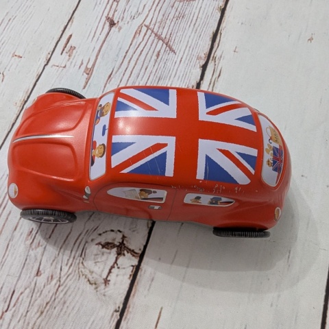 Puszka z flagą w kształcie samochodu z ruchomymi kołami