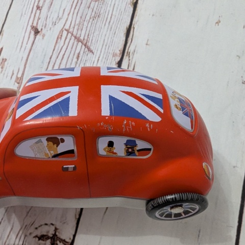 Puszka z flagą w kształcie samochodu z ruchomymi kołami