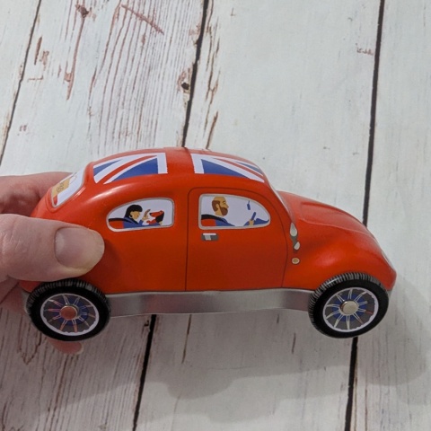 Puszka z flagą w kształcie samochodu z ruchomymi kołami